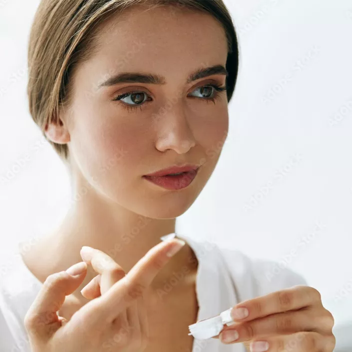 Frau mit Kontaktlinse auf dem Finger