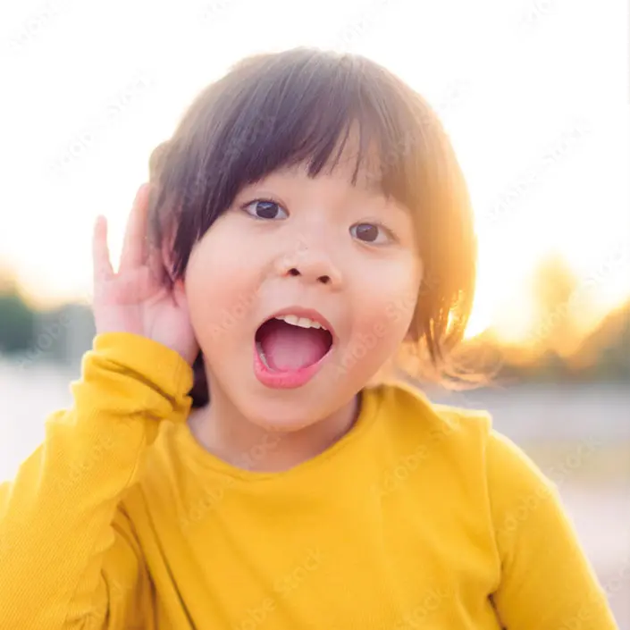 Mädchen hält ihre Hand am Ohr