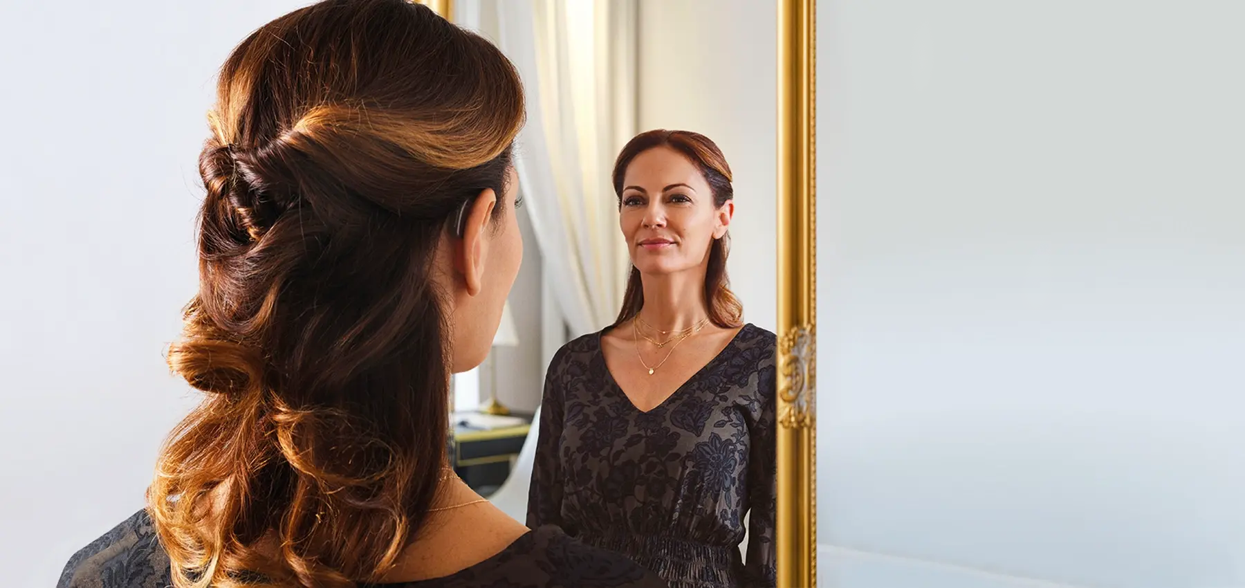 Frau vor dem Spiegel mit Hörgeräten