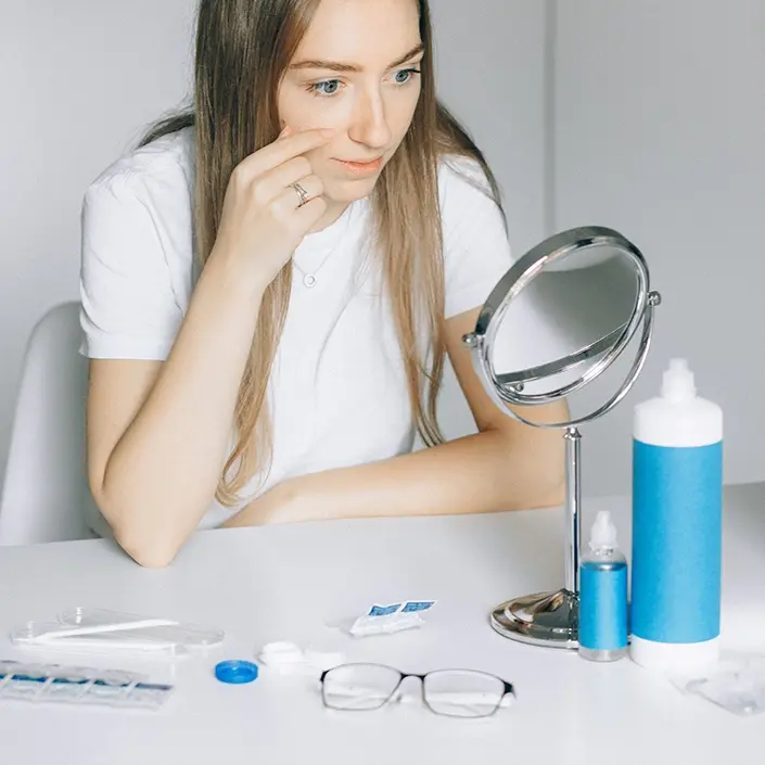 Frau setzt sich Kontaktlinsen ein